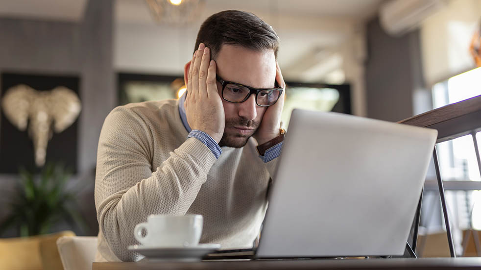 Digital detox stressed man with laptop